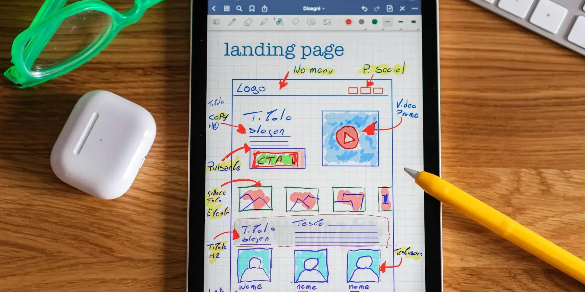 Tablet displaying a landing page mockup with handwritten annotations and design notes