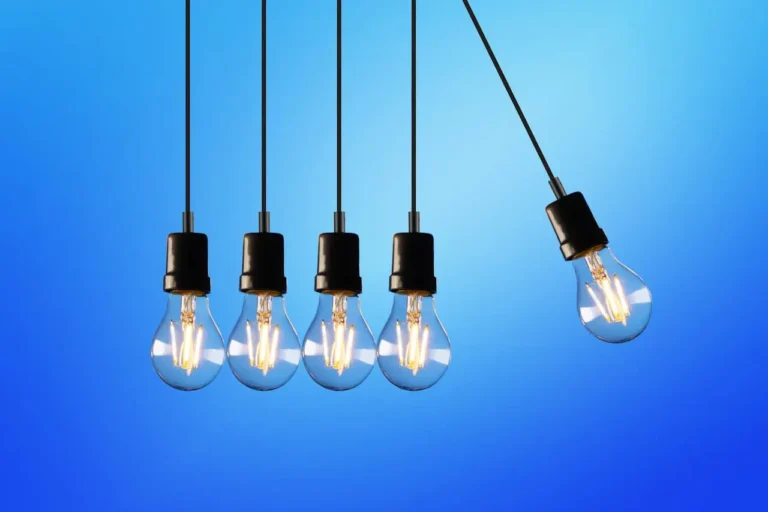Hanging Lightbulbs Against Blue Background Row of hanging lightbulbs against a gradient blue background